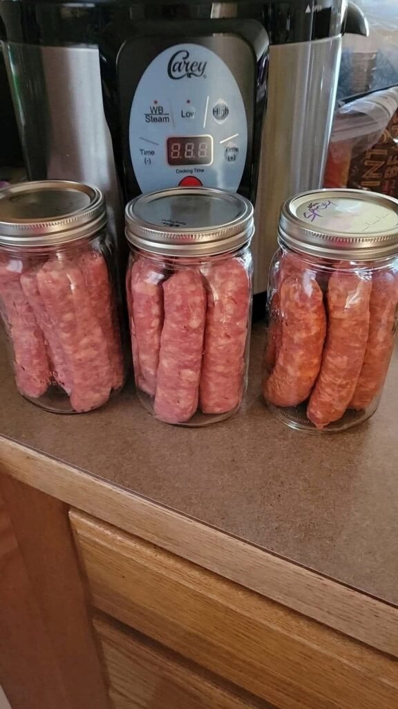 Homemade Canned Sausage Links: A Step-by-Step Guide 1 Glass jars containing homemade sausage links with metal canning lids on a kitchen counter